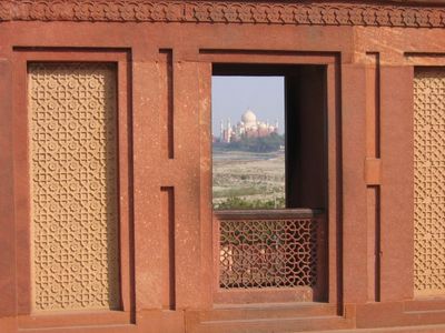 View through a window in Agra Fort with Taj Mahal in distance

